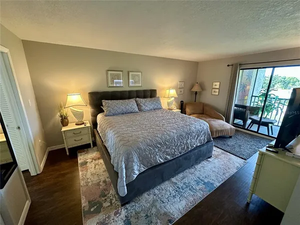 a bedroom with a bed a couch and a large window