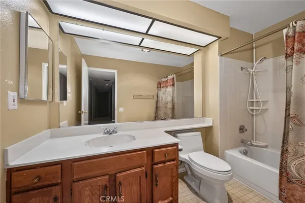 a bathroom with a sink a toilet a mirror and shower