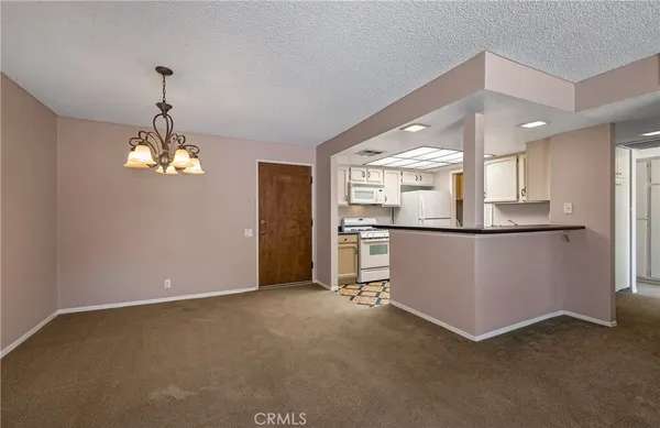 a view of a kitchen with refrigerator and windows