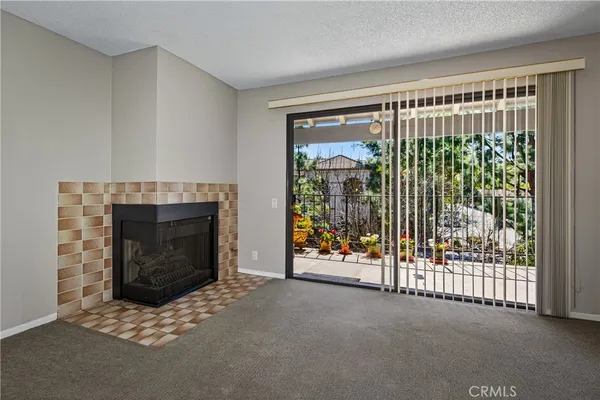 a view of an empty room with floor to ceiling window and fireplace