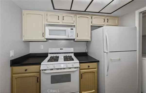 a kitchen with white cabinets and white appliances