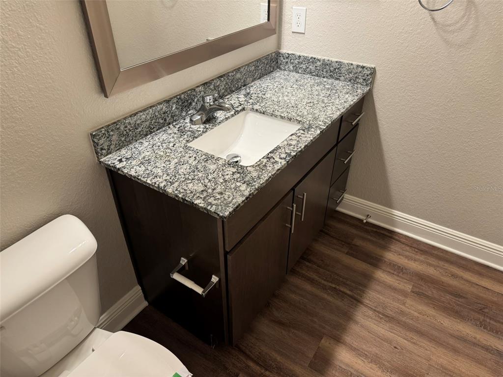 2460 Ann Rou Road, Unit 606 Tavares, FL 32778 - Photo 9 of 18 a bathroom with a granite countertop sink and a toilet
