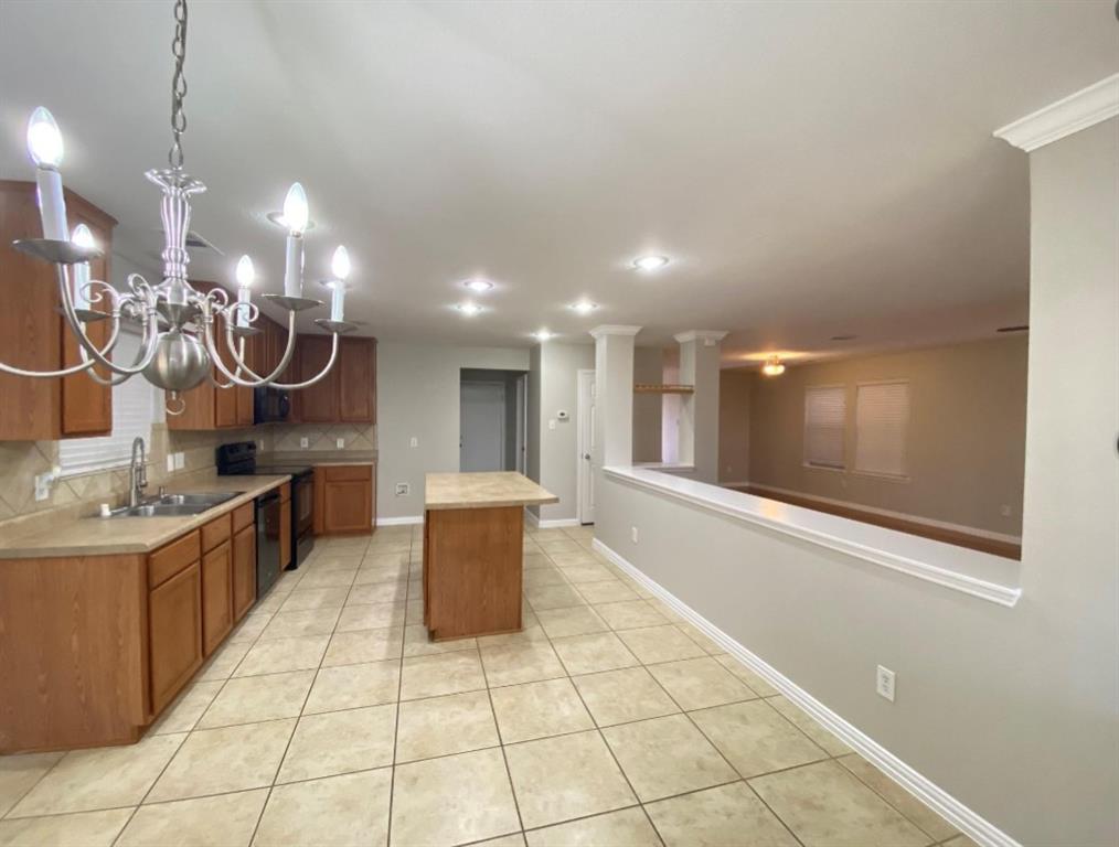 10608 Colfax Drive McKinney, TX 75072 - Photo 11 of 21 a kitchen with stainless steel appliances kitchen island granite countertop a sink and a white cabinets