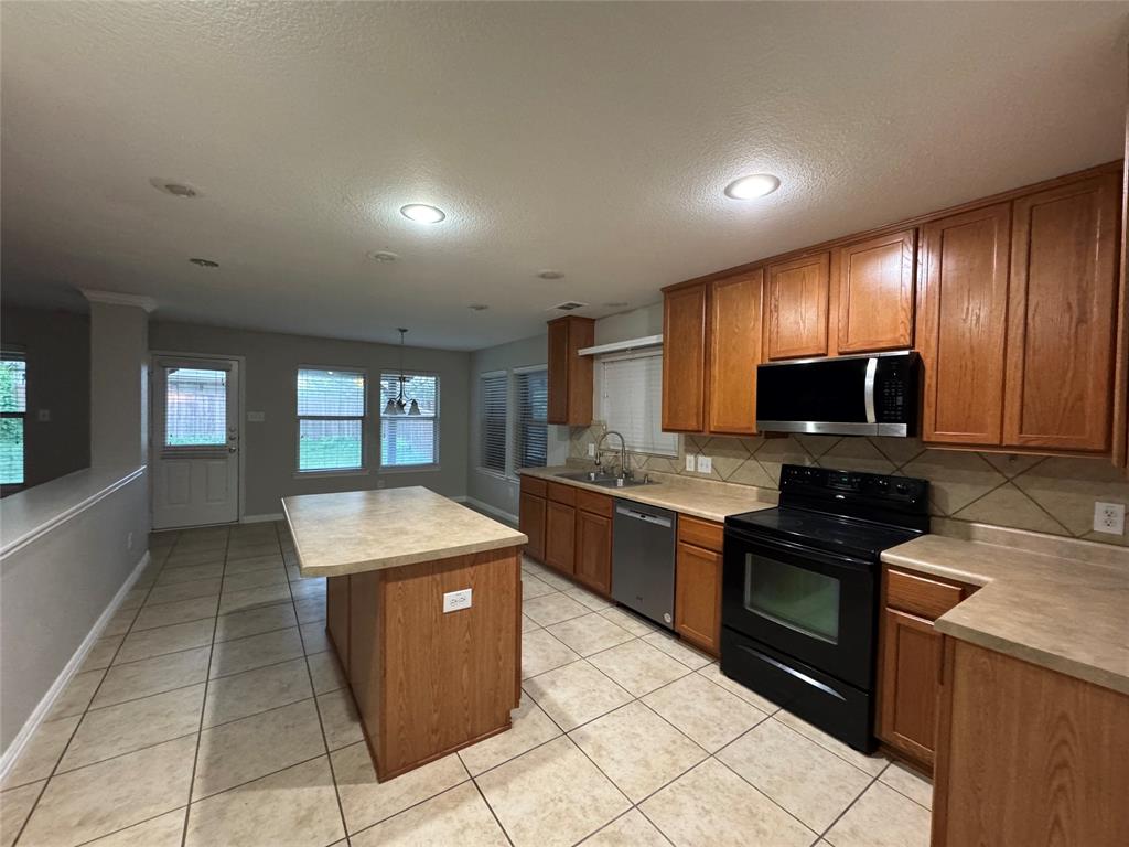 10608 Colfax Drive McKinney, TX 75072 - Photo 5 of 21 a kitchen with stainless steel appliances granite countertop a stove top oven sink and cabinets