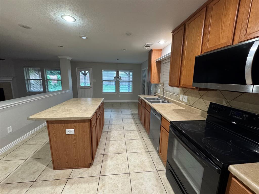 10608 Colfax Drive McKinney, TX 75072 - Photo 6 of 21 a kitchen with stainless steel appliances granite countertop a sink and a stove
