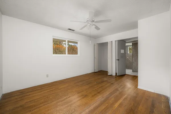 a view of a bedroom with wooden floor and closet