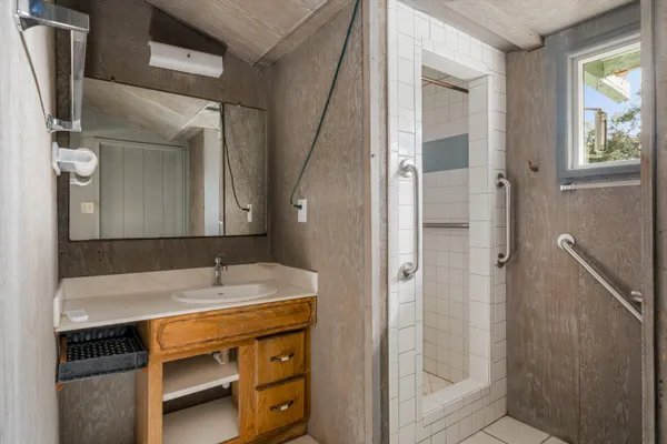 a bathroom with a sink a shower and a mirror