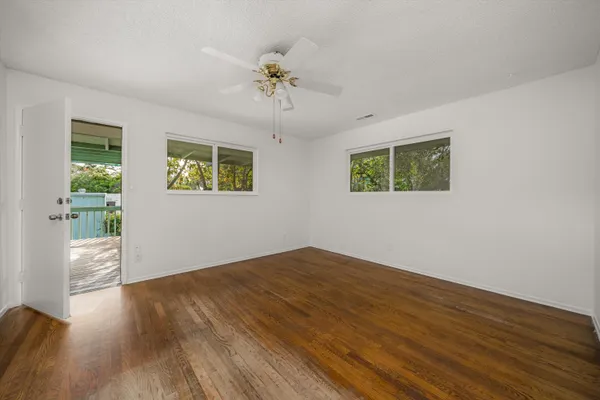 a view of empty room with wooden floor and window