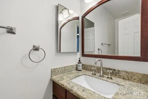 a bathroom with a granite countertop sink and a mirror