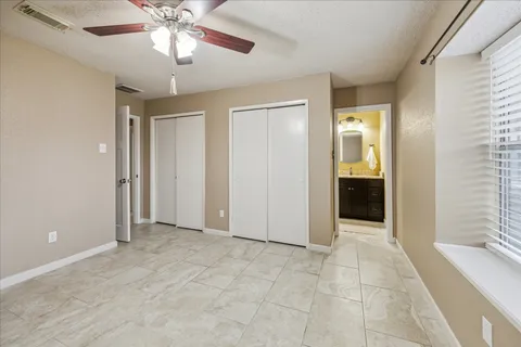 an empty room with closet and a chandelier fan