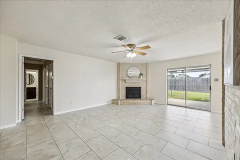 an empty room with fireplace and fan
