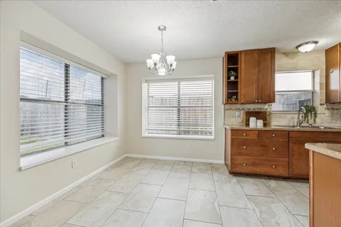 a spacious bathroom with a granite countertop sink a mirror and a bathtub