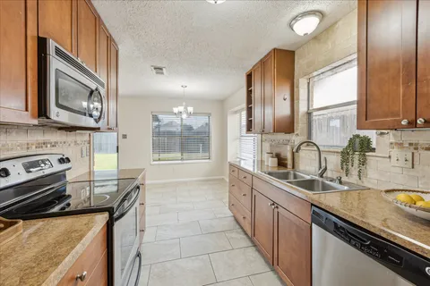 a kitchen with stainless steel appliances granite countertop a sink stove and cabinets