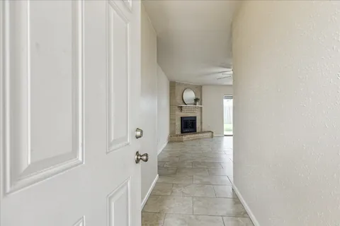 a view of a hallway with wooden floor and a bathroom