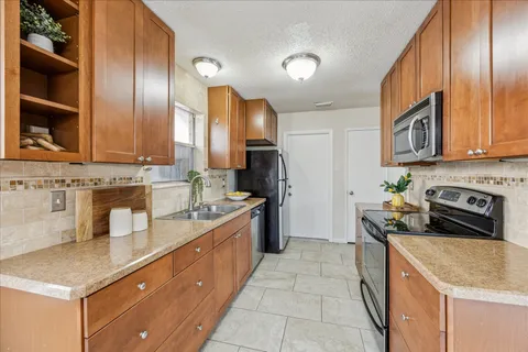 a kitchen with stainless steel appliances granite countertop a sink stove and refrigerator