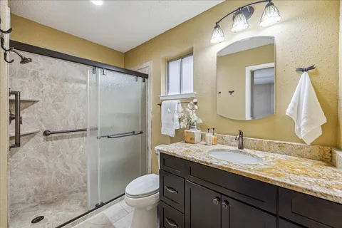 a bathroom with a granite countertop sink toilet and shower