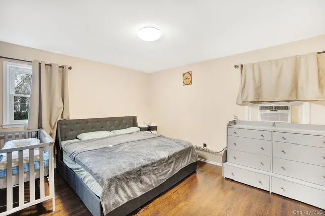 a bedroom with a bed and a window with wooden floor