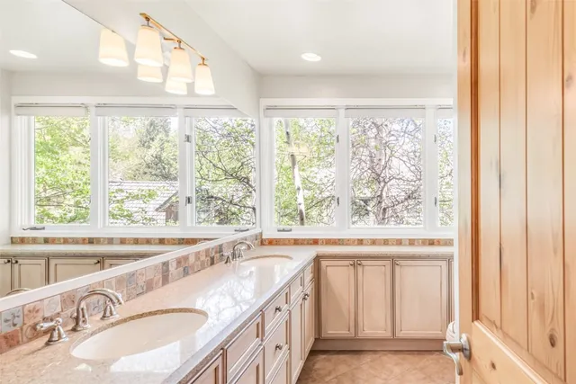a spacious bathroom with a double vanity sink a mirror and a shower
