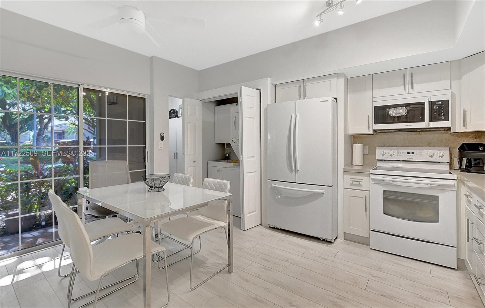 Boca Pointe Boca Raton, FL 33433 - Photo 2 of 32 a white kitchen with a stove a refrigerator and a dining table