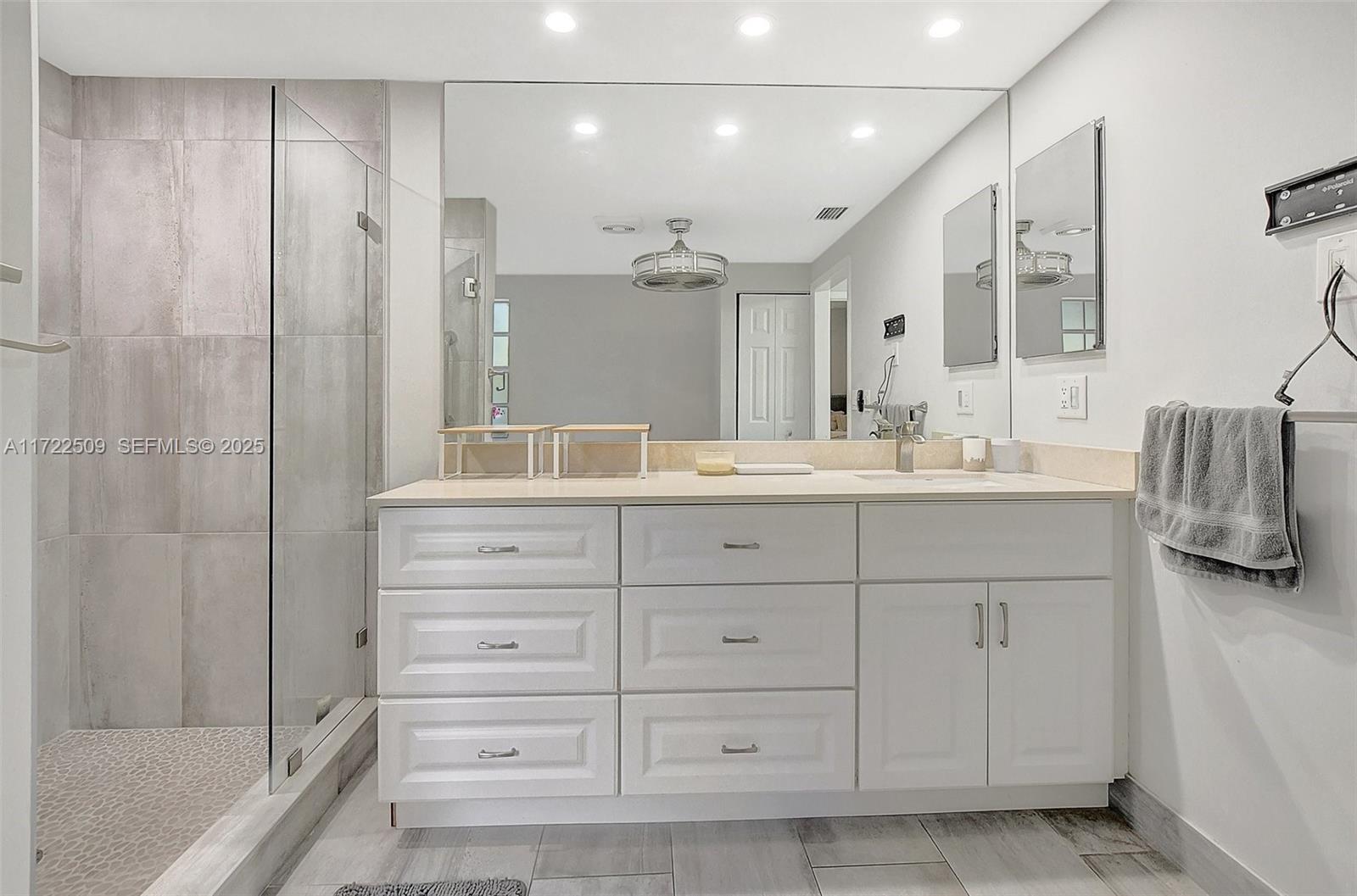 Boca Pointe Boca Raton, FL 33433 - Photo 21 of 32 a bathroom with a double vanity sink a mirror and a shower