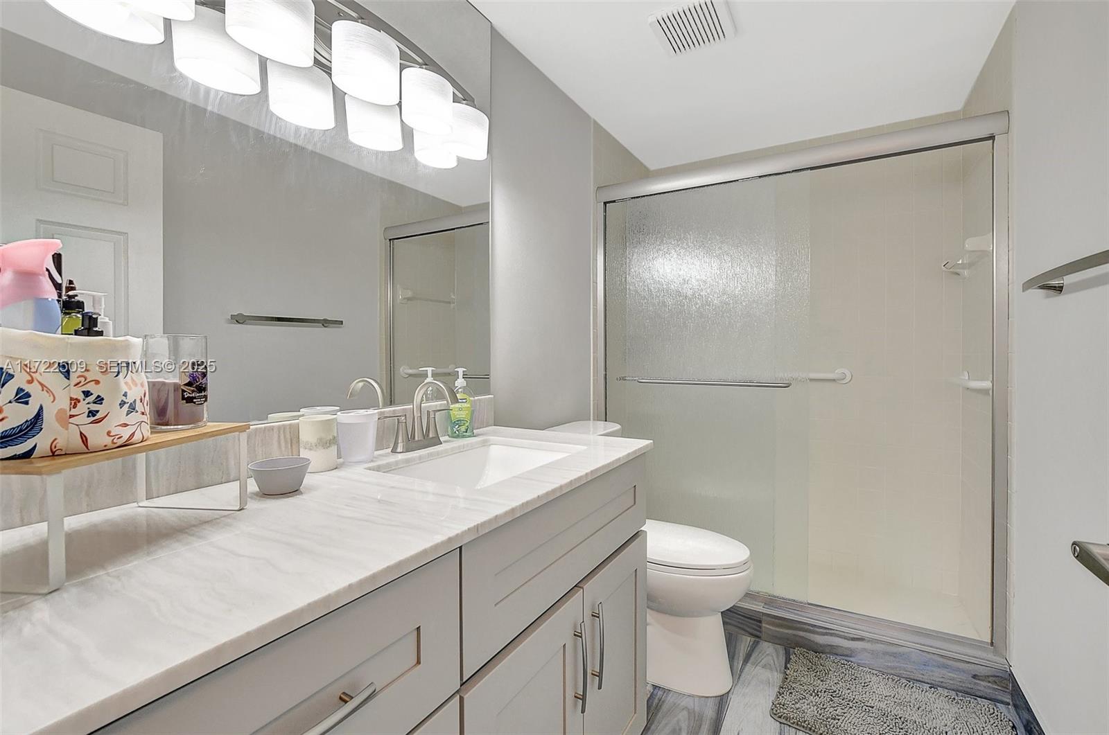 Boca Pointe Boca Raton, FL 33433 - Photo 24 of 32 a bathroom with a sink a toilet and a mirror