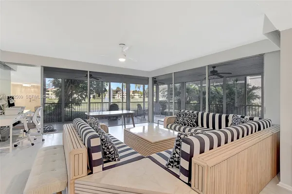 a living room with furniture and floor to ceiling windows