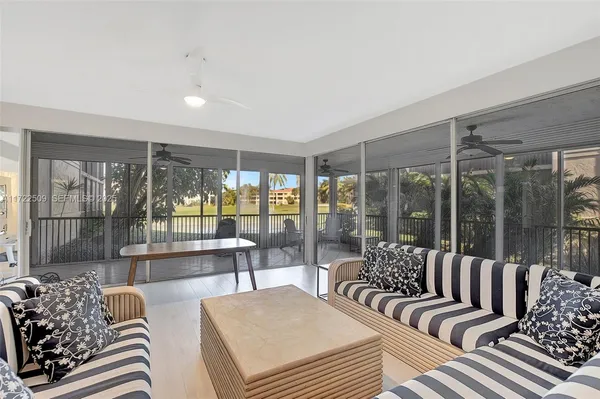 a living room with furniture and a large window with balcony view