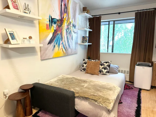 a bedroom with a bed and a painting on the wall