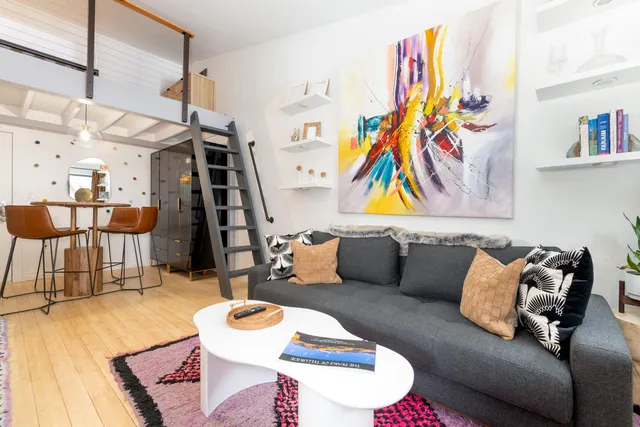 a living room with furniture and a wooden floor