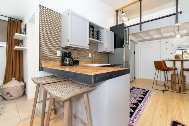 a kitchen with stainless steel appliances granite countertop a table chairs in it and wooden floors