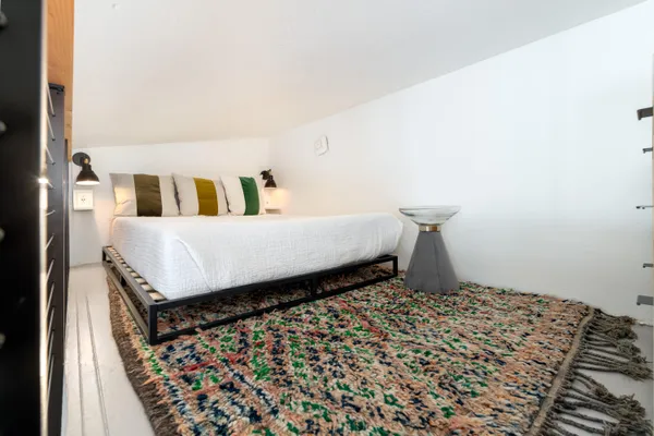 a bedroom with a bed and wooden floor