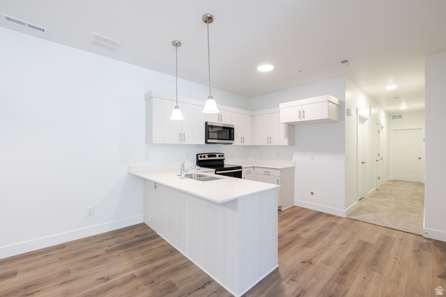 4727 South 690th West, Unit W203 Mapleton, UT 84664 - Photo 12 of 16 Kitchen featuring white cabinetry, stainless steel appliances, and a breakfast bar with pendant lighting