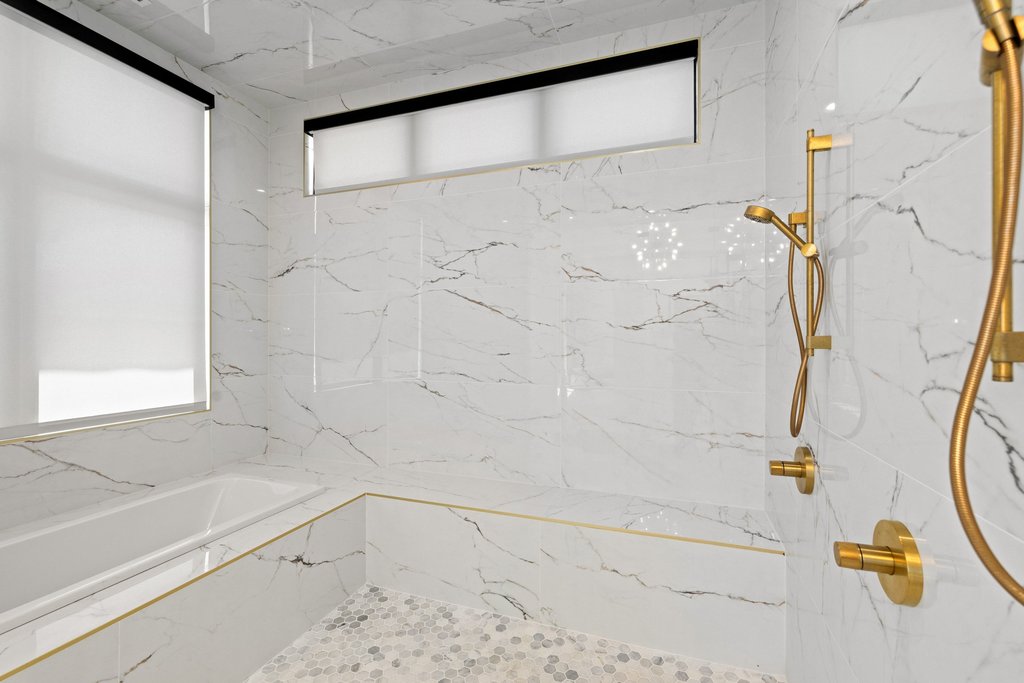 7117 Davenport Divide Road Austin, TX 78738 - Photo 20 of 40 Marble-clad walls and a spacious tub create a luxurious bathroom retreat.