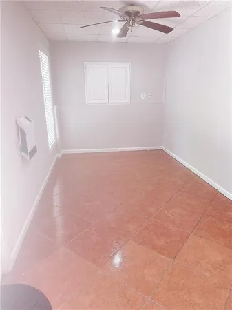 an empty room with a chandelier fan
