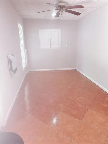 an empty room with a chandelier fan