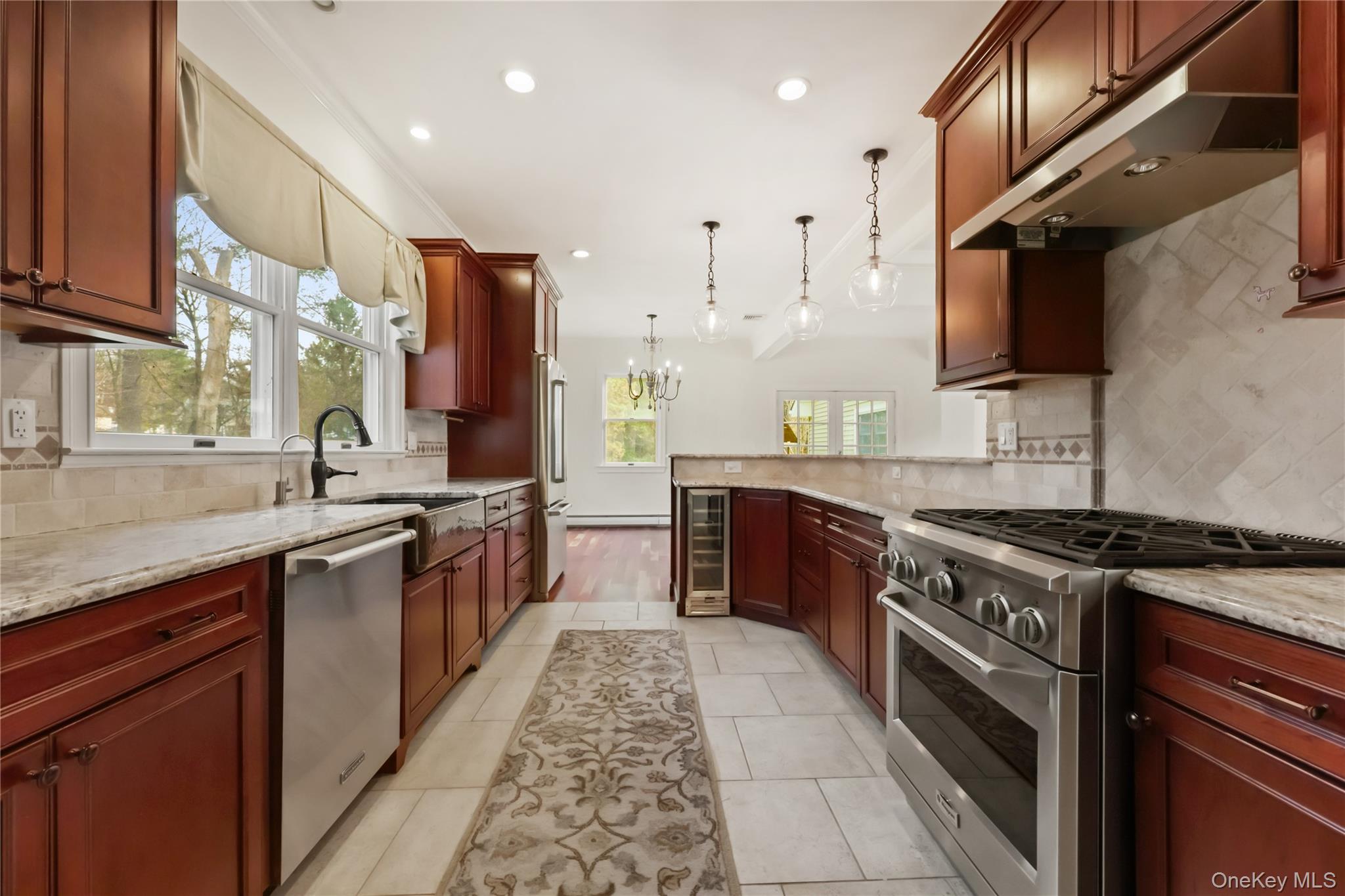 353 Turk Hill Road Brewster, NY 10509 - Photo 13 of 31 Kitchen with appliances with stainless steel finishes, under cabinet range hood, tasteful backsplash, a chandelier, and recessed lighting
