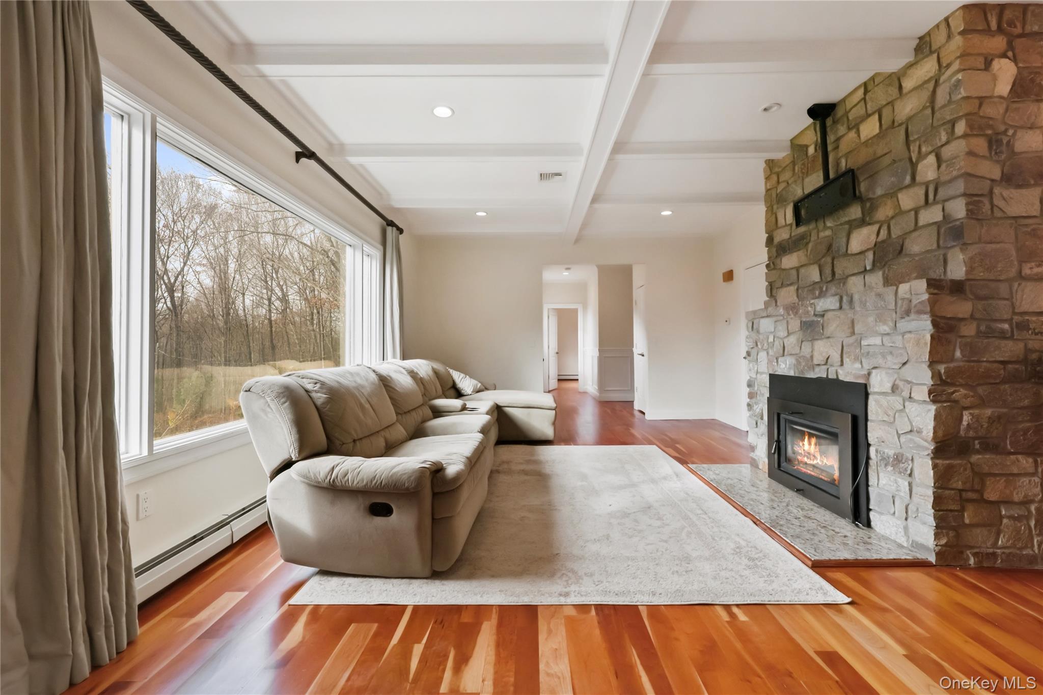353 Turk Hill Road Brewster, NY 10509 - Photo 15 of 31 Living area featuring beam ceiling, a baseboard radiator, wood finished floors, a fireplace, and coffered ceiling