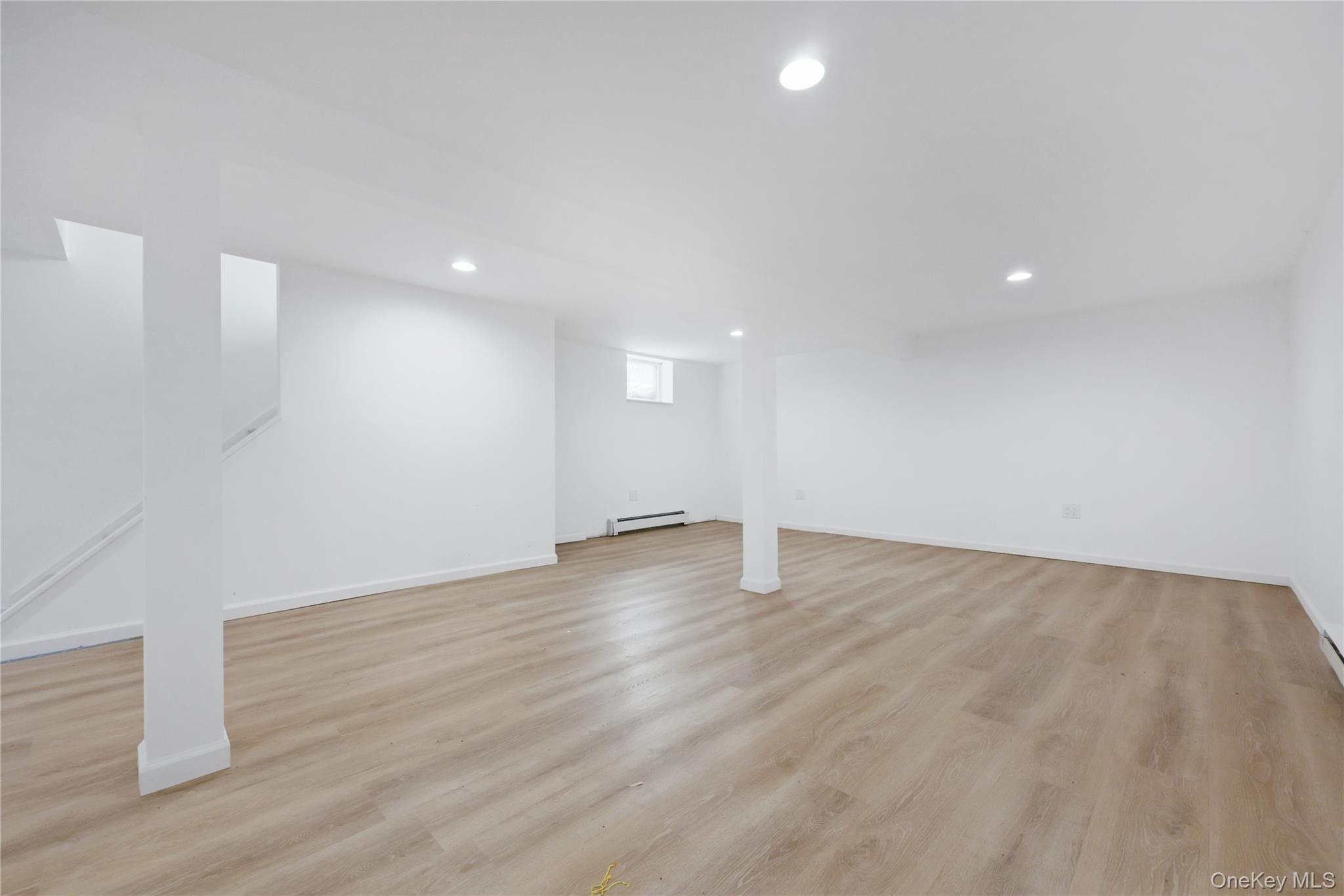 353 Turk Hill Road Brewster, NY 10509 - Photo 27 of 31 Below grade finished area with light wood-style flooring, recessed lighting, a baseboard radiator, and stairs