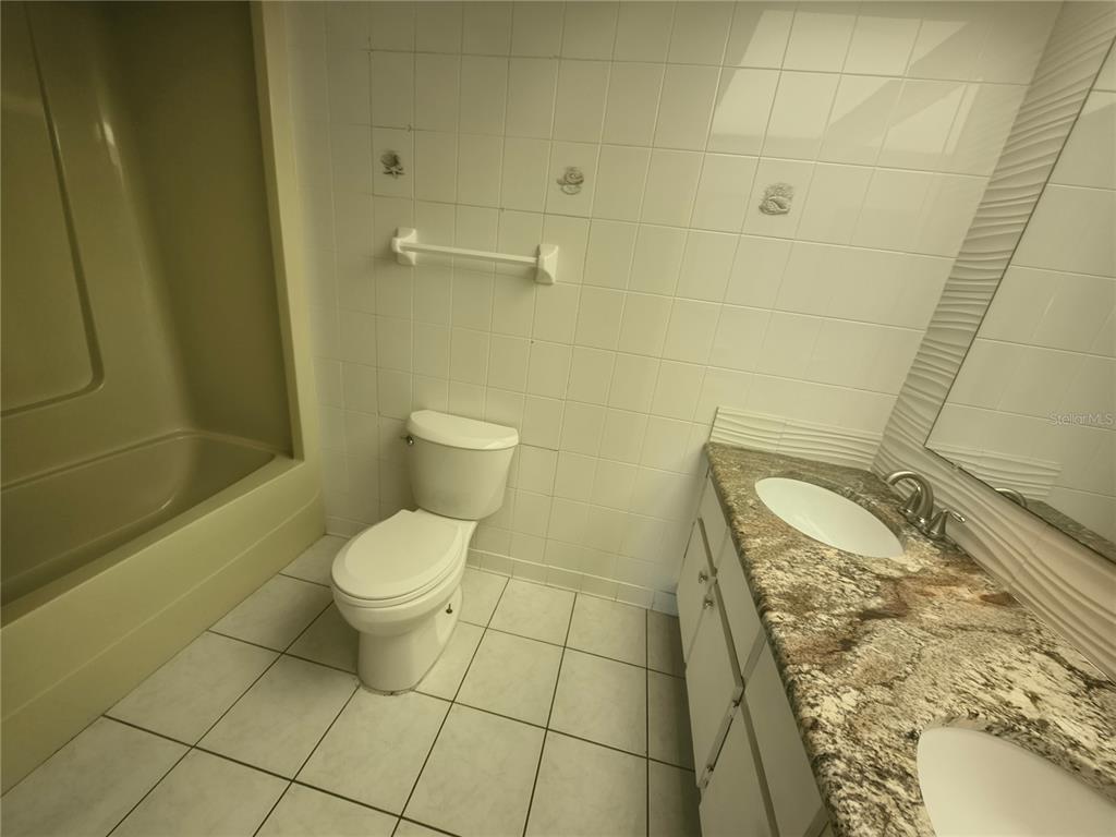 4518 Garnet Drive, Unit 202 New Port Richey, FL 34652 - Photo 28 of 66 a bathroom with a granite countertop toilet and a sink