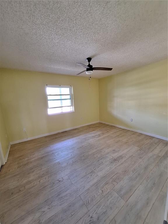 4518 Garnet Drive, Unit 202 New Port Richey, FL 34652 - Photo 31 of 66 a view of empty room with wooden floor and fan