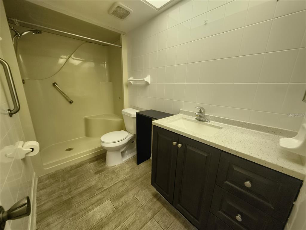 4518 Garnet Drive, Unit 202 New Port Richey, FL 34652 - Photo 34 of 66 a bathroom with a double vanity sink toilet and shower