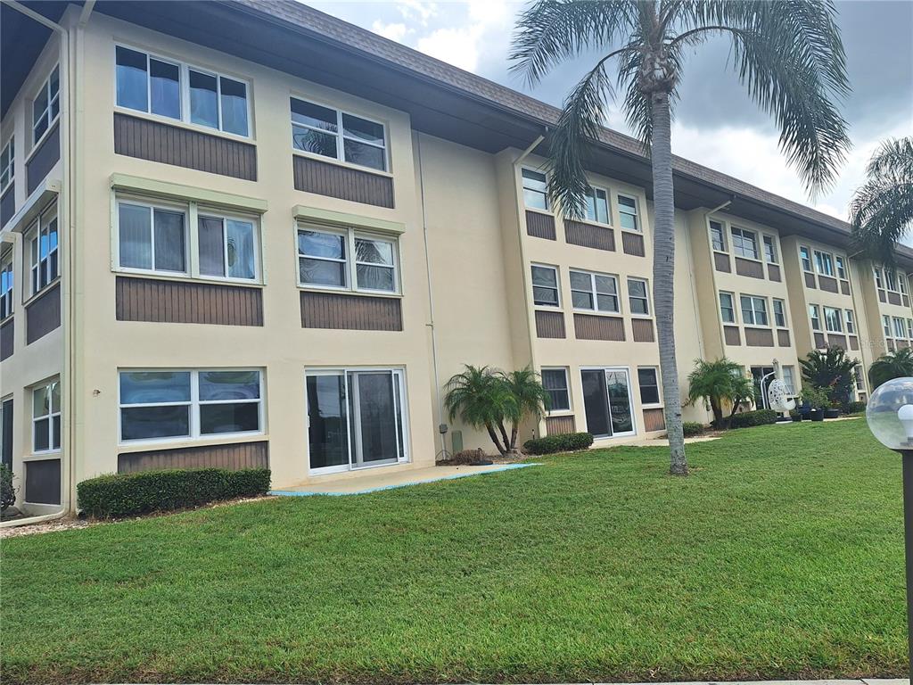 4518 Garnet Drive, Unit 202 New Port Richey, FL 34652 - Photo 39 of 66 a front view of a building with a yard