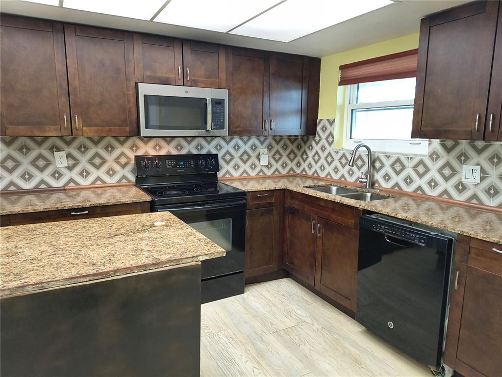 4518 Garnet Drive, Unit 202 New Port Richey, FL 34652 - Photo 7 of 66 a kitchen with a sink stove and microwave