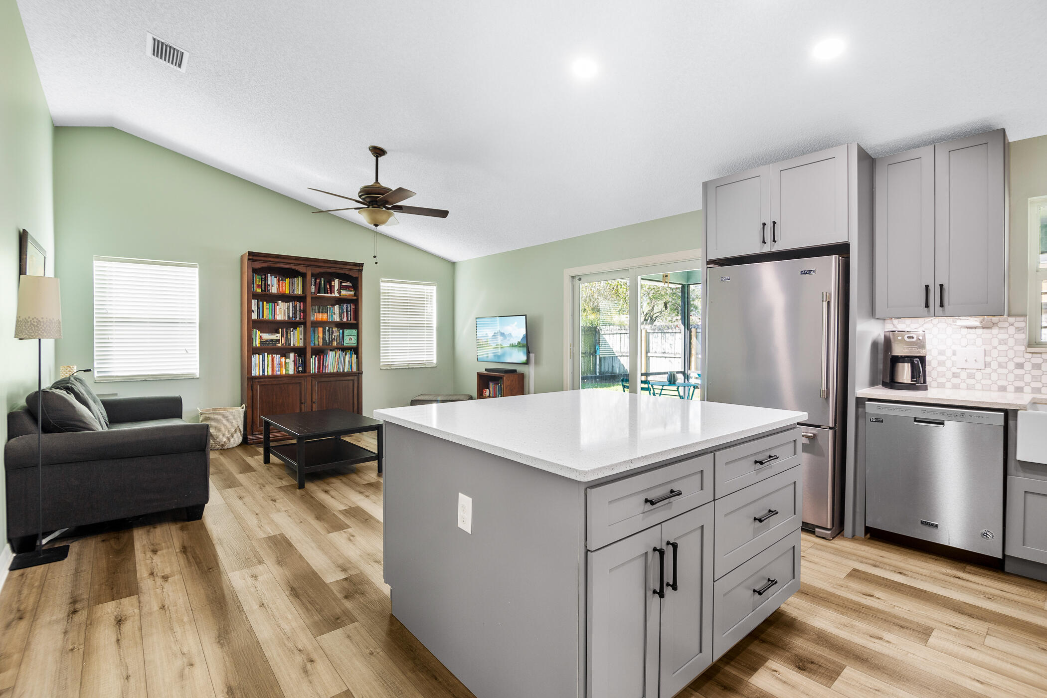 1197 Three Meadows Drive Rockledge, FL 32955 - Photo 15 of 25 a kitchen with a refrigerator a stove a sink dishwasher and a dining table with wooden floor