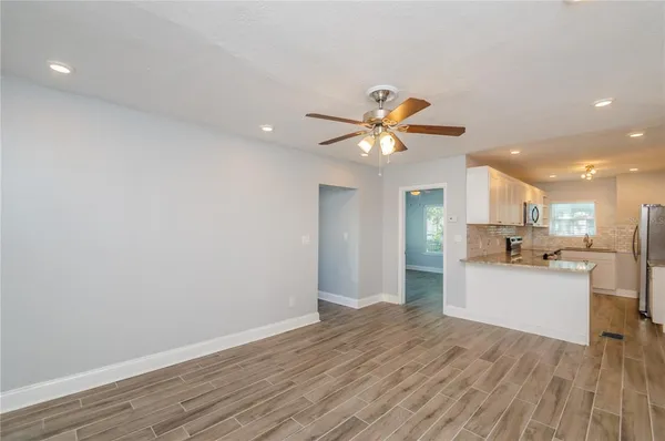 a view of a kitchen with wooden floor and a ceiling fan