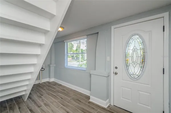 an empty room with wooden floor cabinet and mirror