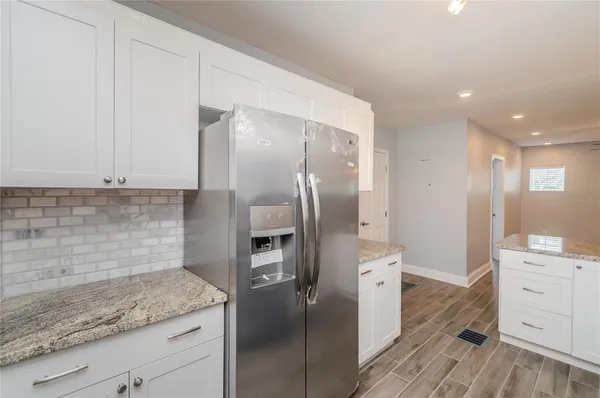 a kitchen with a refrigerator sink and cabinets
