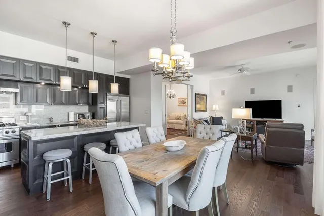a view of a dining room and livingroom with furniture wooden floor a chandelier