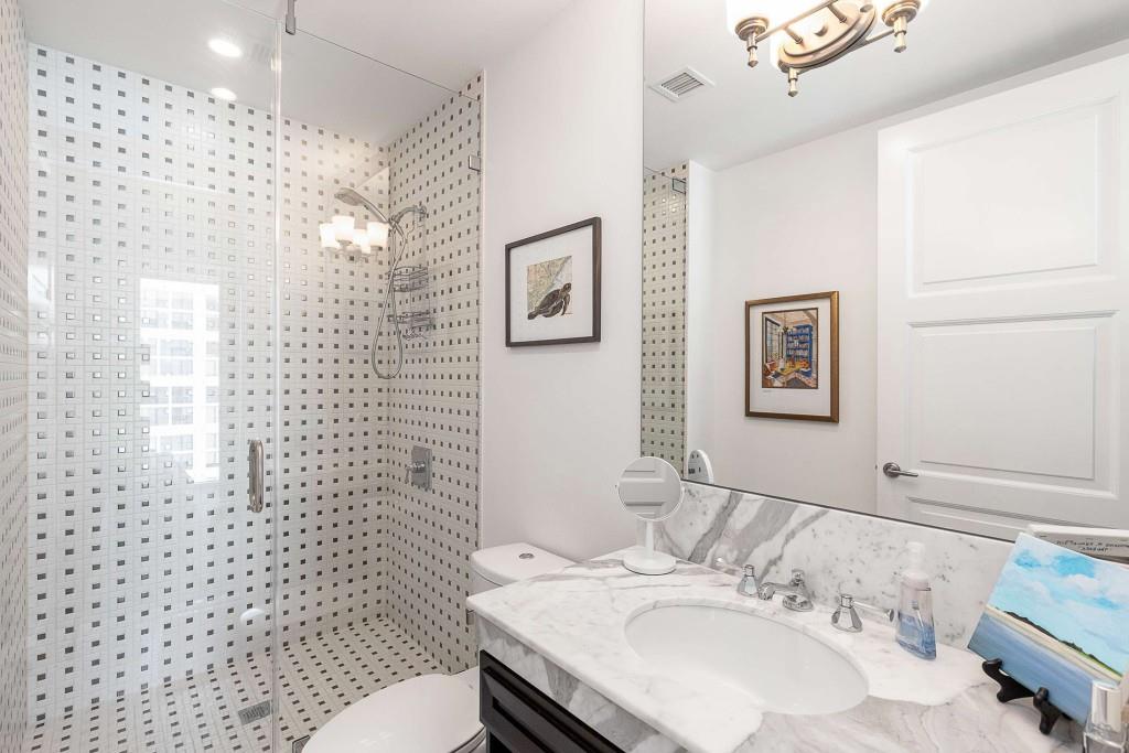 1820 Peachtree Road Northwest, Unit 1409 Atlanta, GA 30309 - Photo 22 of 44 a bathroom with a sink a toilet and shower