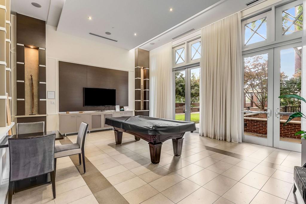 1820 Peachtree Road Northwest, Unit 1409 Atlanta, GA 30309 - Photo 34 of 44 a living room with furniture a flat screen tv and floor to ceiling window